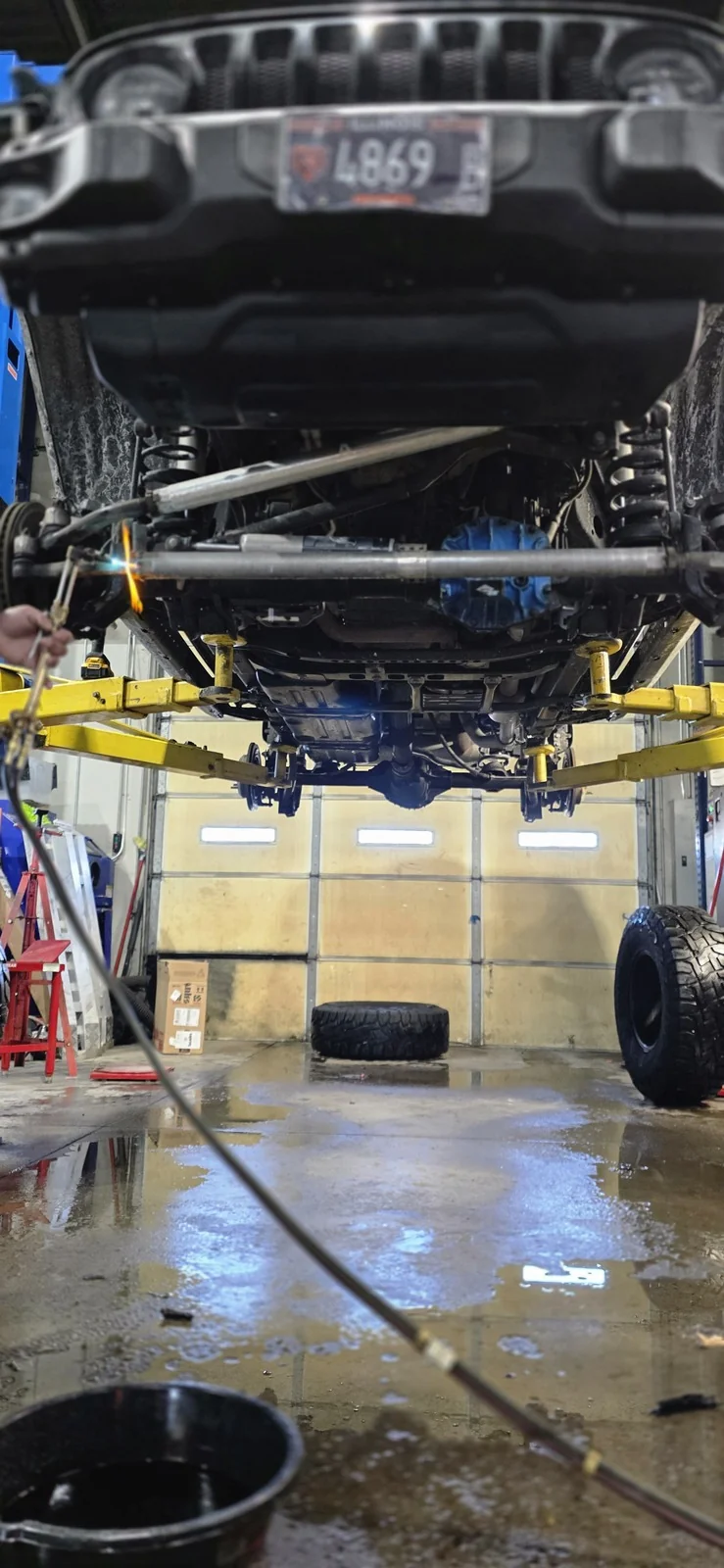 Technician heating a steering link on the lift